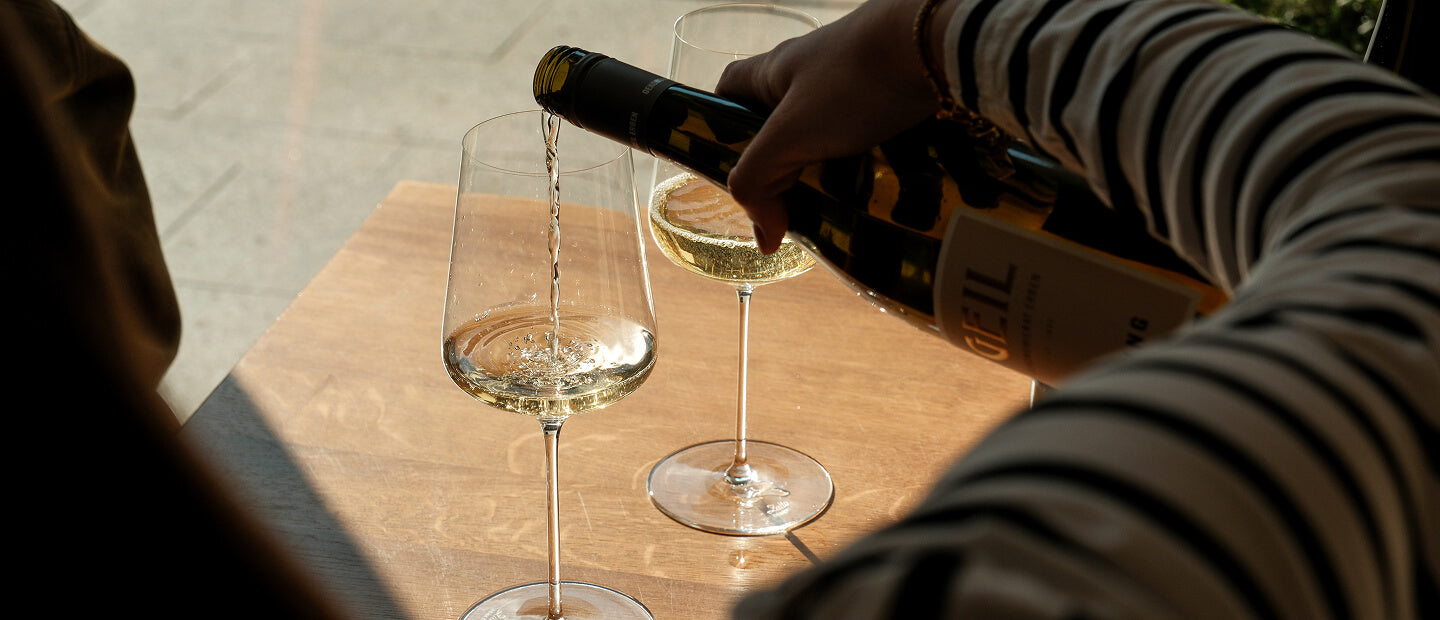 Riesling, der ins Glas eingeschenkt wird